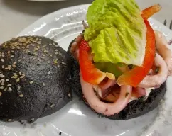 Step <h5><u style=""><b>Montaje:</b></u><span style="font-weight: normal;"> Con un cuchillo de sierra, abra los panes por la mitad para rellenarlos. Úntelos con mayonesa o alioli y rellene con las hojas de lechuga, el pimiento amarillo, el pimiento rojo y los calamares. Sirva inmediatamente.</span></h5> illustration