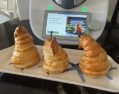 Step <p>Corte el hojaldre en tiras de 2x40cm. </p><p>Envuelva cada pera con tiras de hojaldre súper poniendo ligeramente los bordes y presionen con los dedos las uniónes . Con un trocito de papel de Horno o de papel de aluminio , cubrimos el rabillo para que no se queme . </p><p>Opcional , podemos dibujar una hoja en el hojaldre , recortar y decorar la pera . </p><p>Pincelamos con el huevo batido y colocamos las peras en la bandeja preparada . </p> illustration