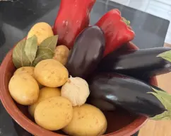 Step <p>Ponemos las patatas cortadas en un recipiente con agua y sal . También igualmente cortamos las berengenas y las colocamos en otro bol con agua con sal para que saquén el amargor . </p><p>Limpiamos y cortamos los pimientos , me gusta chascarlos con las manos . </p> illustration