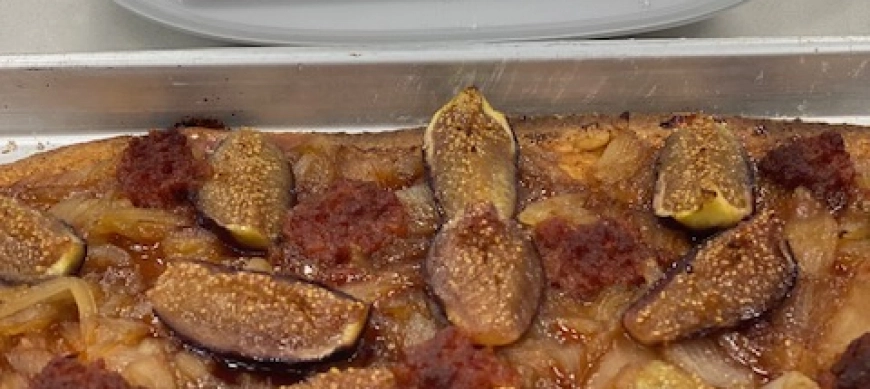 COCA DE CEBOLLA CARAMELIZADA CON HIGOS , SOBRASADA Y MIEL .
