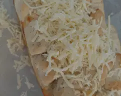 Step <p>Pon en el fondo del molde 20 trozos de masa, pintalos con mantequilla fundida y espolvorea con queso rallado. </p><p>Esto lo repetimos tres veces.</p> illustration