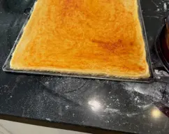 Step <p>Espolvoreamos con harina la superfície de Trabajo , y con la ayuda de un rodillo estiramos la masa , bien finita . Luego Cojemos una bandeja tipo llauna ,y la espolvoreamos bien de harina , y Colocamos la masa Estirada encima . Una vez colocado ,le pasamos el rodillo y le cortamos el sobrante de masa , con un cuchillo.Luego le hago un borde por todos los lados de la masa apretando con los dedos . Se espolvorea la masa de sal , pimentón y un chorrito de aceite y con la mano la extendemos por toda la pasta. </p> illustration